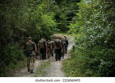 Military Platoon Soldiers Are Walking Along The Road In The Forest. A Group Of People In Military Uniform On Their Way To Battle. Military Of Ukraine. War In Ukraine. General Plan