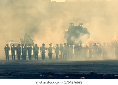Military police riot response to a protest with tear gas, smoke, fire, explosions. Political expression, riot, protest, demostration and military concept. - Shutterstock ID 1764276692