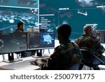 Military professionals in a mission control center employs modern technology to analyze satellite imagery and data, tracking threats and support intelligence operations. Surveillance system.