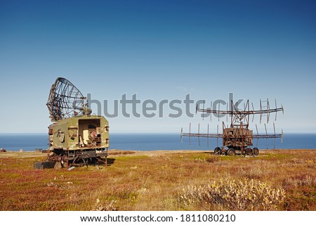 Military radar and locator on the car. Abandoned equipment on the background of the autumn landscape, sea and blue sky