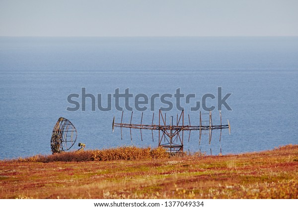 Military radar\
and locator on the car. Abandoned equipment on the background of\
the autumn landscape, sea and blue\
sky