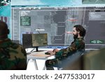 Military recruit collecting real time data from satellite radar system, working on reconnaissance for the infantry units deployed. Army personnel checking surveillance footage in power base.
