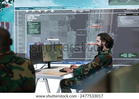 Military recruit collecting real time data from satellite radar system, working on reconnaissance for the infantry units deployed. Army personnel checking surveillance footage in power base.
