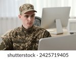 Military service. Young soldier working in office