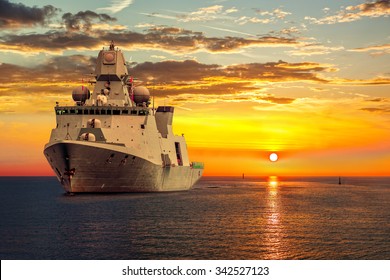 The Military Ship On Sea At Sunrise. 