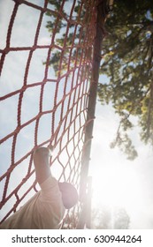 Military Soldier Climbing Rope During Obstacle Course In Boot Camp