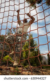 Military Soldier Climbing Rope During Obstacle Course In Boot Camp