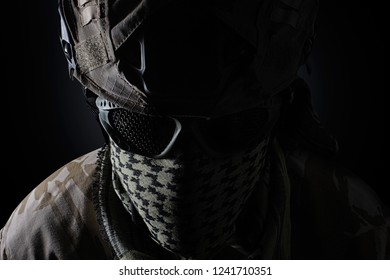 Military soldier head with camouflage  helmet, protective glasses and military scarf front closeup view on black background.
