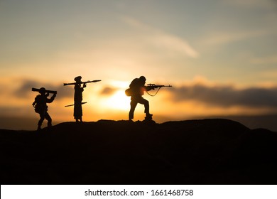 Military soldiers silhouettes with bazooka and rpg. War Concept. Military silhouettes fighting scene on war fog sky background, Mojahed with rpg and us soldier with bazooka at sunset. Attack scene - Shutterstock ID 1661468758