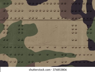 Military steel bodywork painted khaki metal plates mounted with rows of rivets and bolts, with small details. The photo has a copy space in the center. Background for army design postcard. 