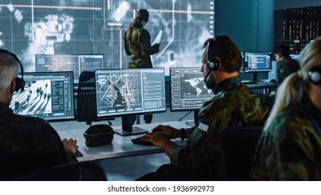 Militärischer Überwacher, der an einer City Tracking Operation in einer Zentrale für Cyberkontrolle und Überwachung für die Verwaltung der nationalen Sicherheit, Technologie und Kommunikation der Streitkräfte arbeitet.