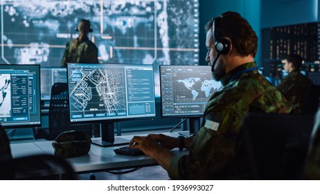 Militärischer Überwacher, der an einer City Tracking Operation in einer Zentrale für Cyberkontrolle und Überwachung für die Verwaltung der nationalen Sicherheit, Technologie und Kommunikation der Streitkräfte arbeitet.