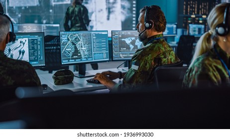 Military Surveillance Officer Working on a City Tracking Operation in a Central Office Hub for Cyber Control and Monitoring for Managing National Security, Technology and Army Communications.