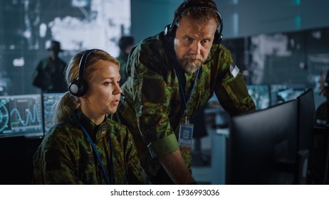 Military Surveillance Officers Talking Next To A Computer Screen In Central Office For Cyber Operations, Control And Monitoring For Managing National Security, Technology And Army Communications.