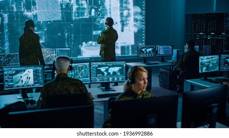 Military Surveillance Team of Officers Locked a Target on a Vehicle from a Satellite and Monitor it on a Big Display in Office for Cyber Operations for Managing Security and Army Communications. - Shutterstock ID 1936992886