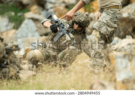Military team secures an area while providing assistance to a simulated casualty during a field training operation