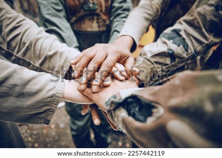 Military, team work or hands in a huddle for a mission, strategy or motivation on a paintball battlefield. Goals, collaboration or army people with support in a partnership or group of ready soldiers