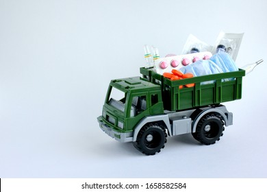 Military Toy Car With Pills, Medical Masks, Syringes And Ampoules On Light Background. Concept Of Humanitarian Aid, Health Care. Space For Text.