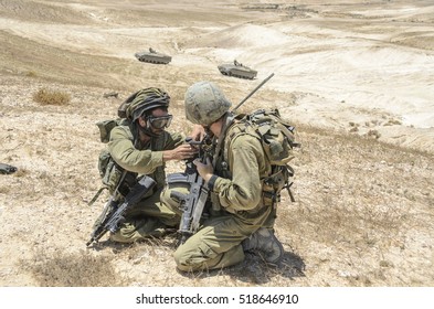 MILITARY TRAINING ZONE, ISRAEL - JUNE 17, 2015: Israel Army Soldiers Helping Each Other While Kneeling. Soldiers Preparing To Storm Terrorist Objectives. Commando Soldiers During Combat Training.