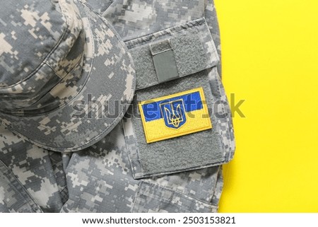 Military uniform with badge of Ukrainian army on yellow background
