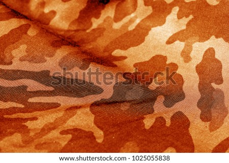 Military uniform pattern with blur effect in orange tone. Abstract background and texture.