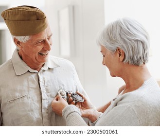 Military veteran, man and woman with medal, uniform and smile together with memory, pride and success. Elderly couple, army badge or regalia with happiness, check and retirement from service in house - Powered by Shutterstock