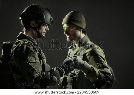 Military and war concept. Two brave soldiers in Protective Combat Uniform. Studio portrait on a black background.