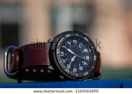 military watch with arabic numbers and black dial