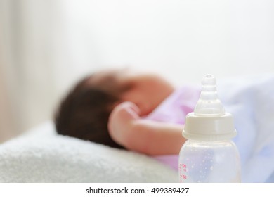 Milk bottle with baby sleeping