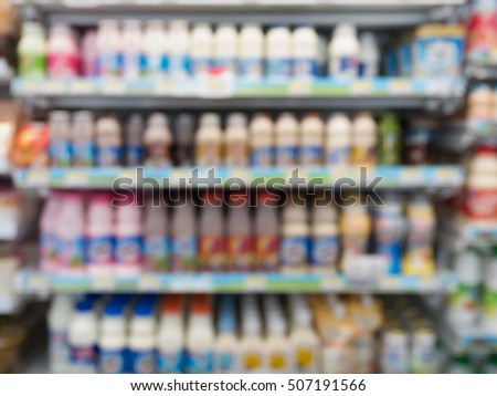 milk bottles on the freezer shelves in supermarket or convenience store