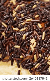 Milk bread with a soft white interior, topped generously with chocolate sprinkles and a touch of white topping. Photographed against a clean white background.
