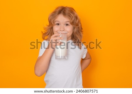 Milk. Child with glass of milk on studio yellow background. Kid with milk moustache. Fun portrait of cute child with milk mustache and funny face.