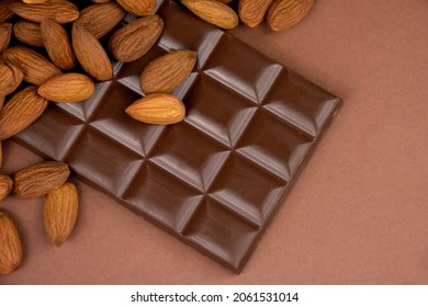 Milk chocolate bar with almonds brown frame top view stock images. Whole almond chocolate on a brown background with copy space for text stock images