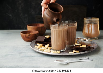 Milk Chocolate Poured From Jug Into Glass