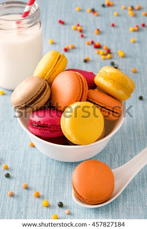 Foto Bild Milch und farbige Makronen auf blauem Hintergrund