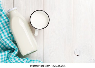 Milk cup and bottle on wooden table. Top view with copy space  - Powered by Shutterstock