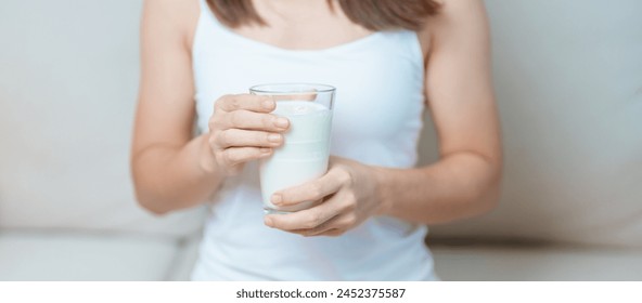 Milk drink and Daily Routine concept. Young woman Drinking milk with high calcium and nutrition at home, woman holding soy milk on glass with protein. Healthy, wellness and happy lifestyle - Powered by Shutterstock