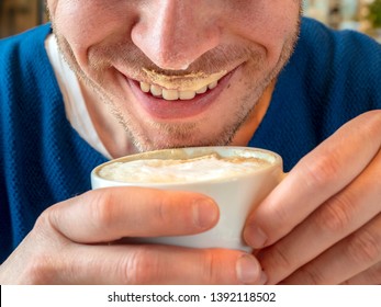 Milk Foam On A Happy Man's Lips. Closeup Of Coffee Foam In A White Cup.