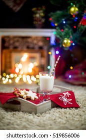 Milk And Gingerbread Cookie On Wooden Tray For Santa Against Bokeh Background