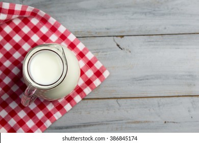 Milk In A Glass Jug On A Wooden Table, Top View