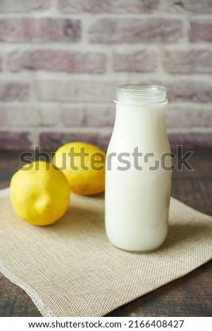  milk jar and yellow lemon on table 