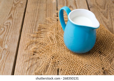 Milk jug over wooden rustic background - Powered by Shutterstock