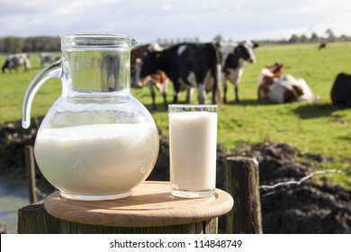 Milk on wooden plate with cows on the background