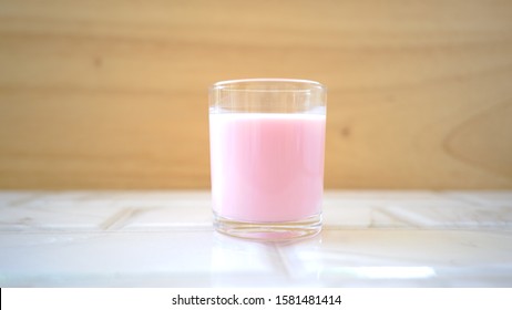 Milk in pink, Pink milk on wooden background