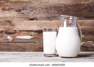 Milk In A Pitcher And A Glass On An Old Table