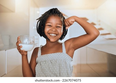 Milk, portrait and African girl with muscle from healthy drink for energy, growth and nutrition in the kitchen. Happy, smile and child flexing muscles from calcium in a glass and care for health - Shutterstock ID 2267074075
