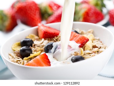  Milk Pouring Into Bowl Of Cereals With Fresh Berries