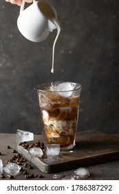 Milk Pouring Into The Cold Coffee. Making Cold Brew Coffee Concept.