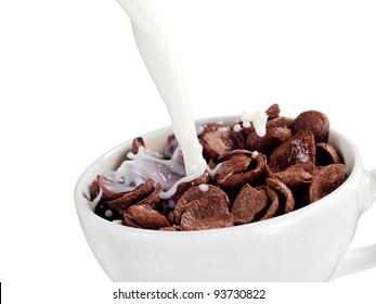 Milk Pouring Into A Cup With Chocolate Cereal Flakes