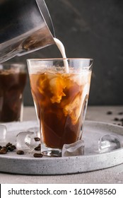 Milk pouring into glass with coffee - Shutterstock ID 1610498560
